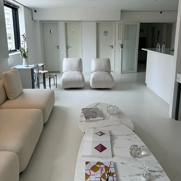 Sala de espera da Elvare, com sofás claros e mesa de mármore